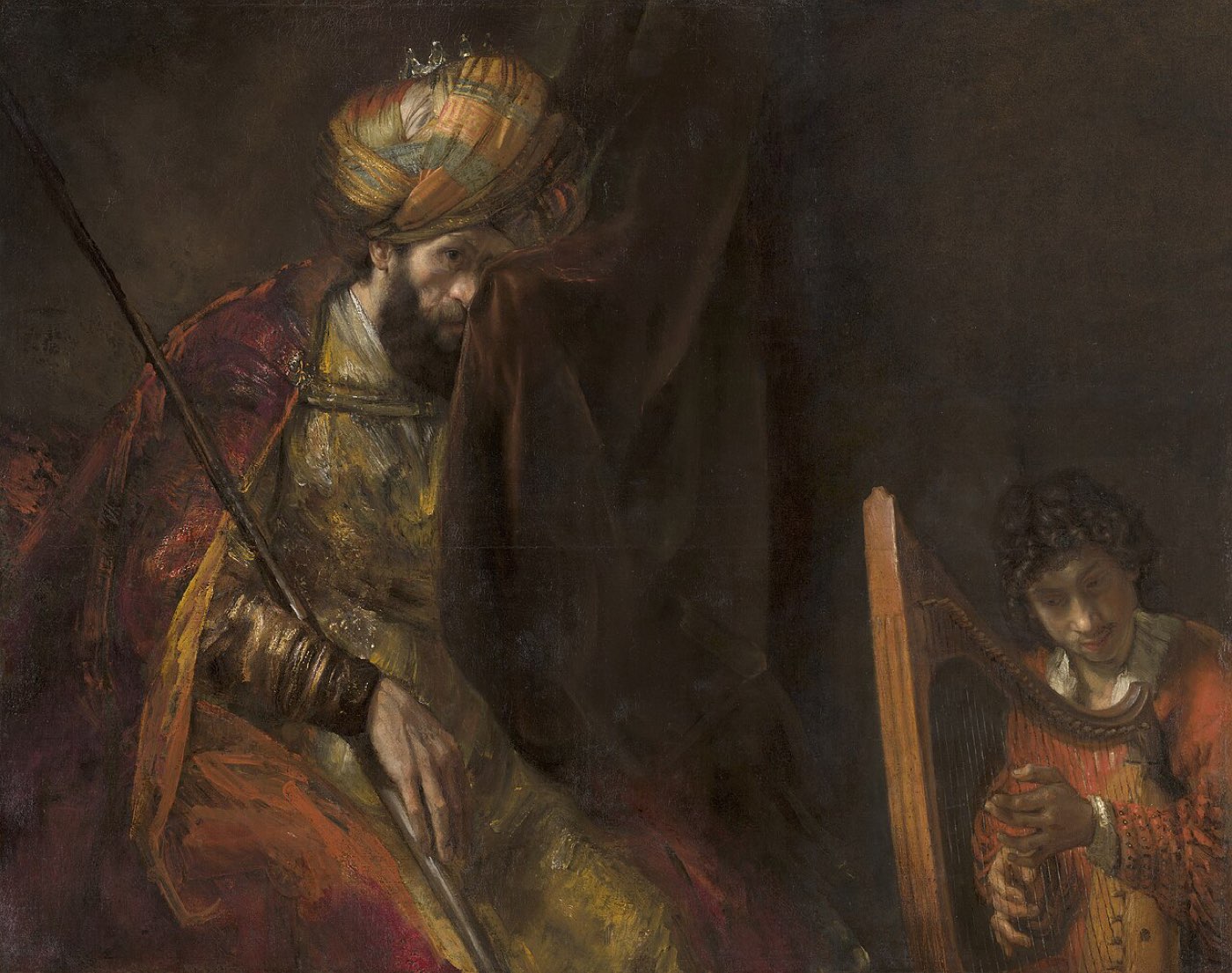Rembrandt's Saul and David: the brooding king clutches a curtain to his face while young David bends over the harp in the shadows.