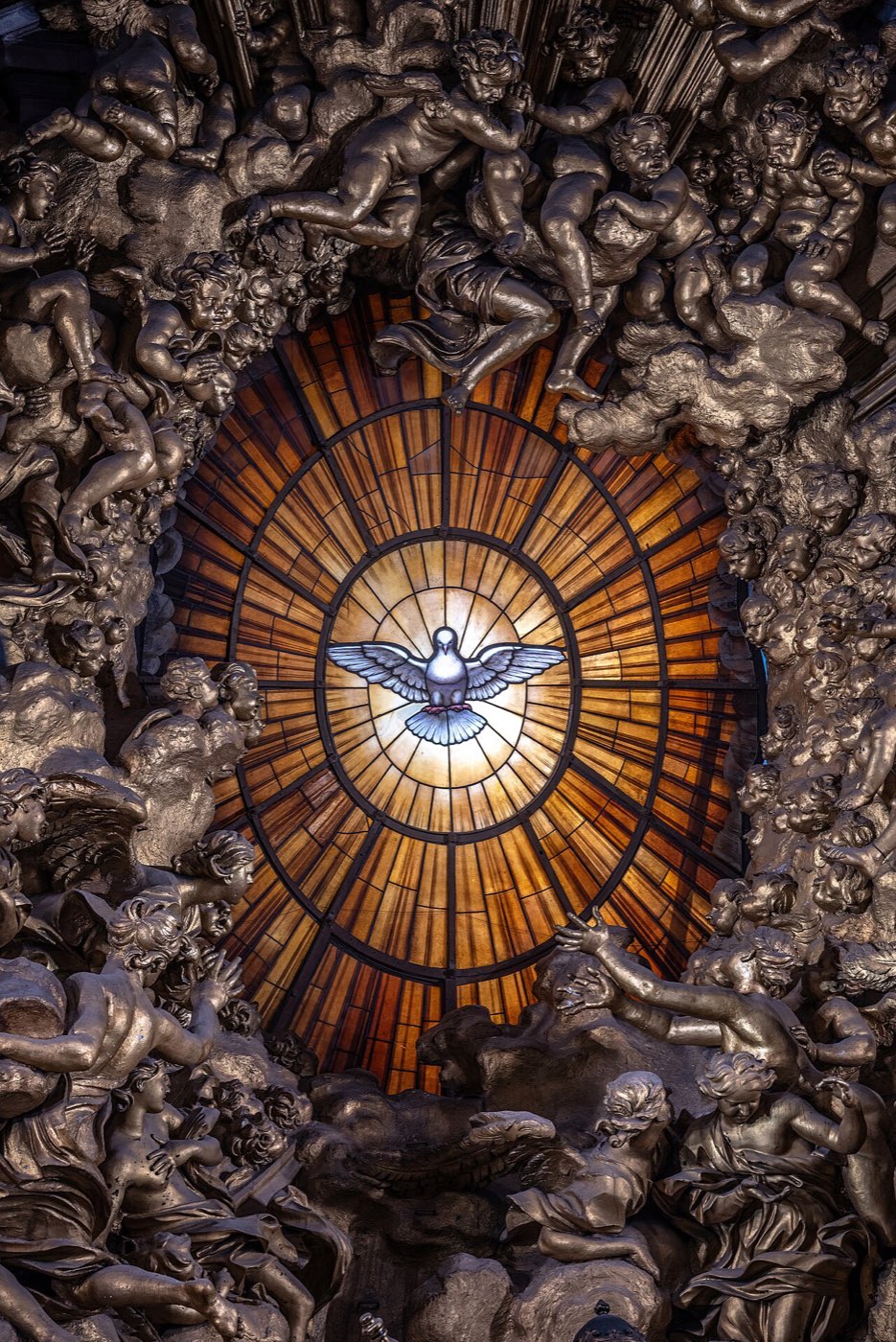 Bernini's alabaster window in St. Peter's: the dove of the Holy Spirit glowing white at the center of golden rays, ringed by gilded clouds and angels.