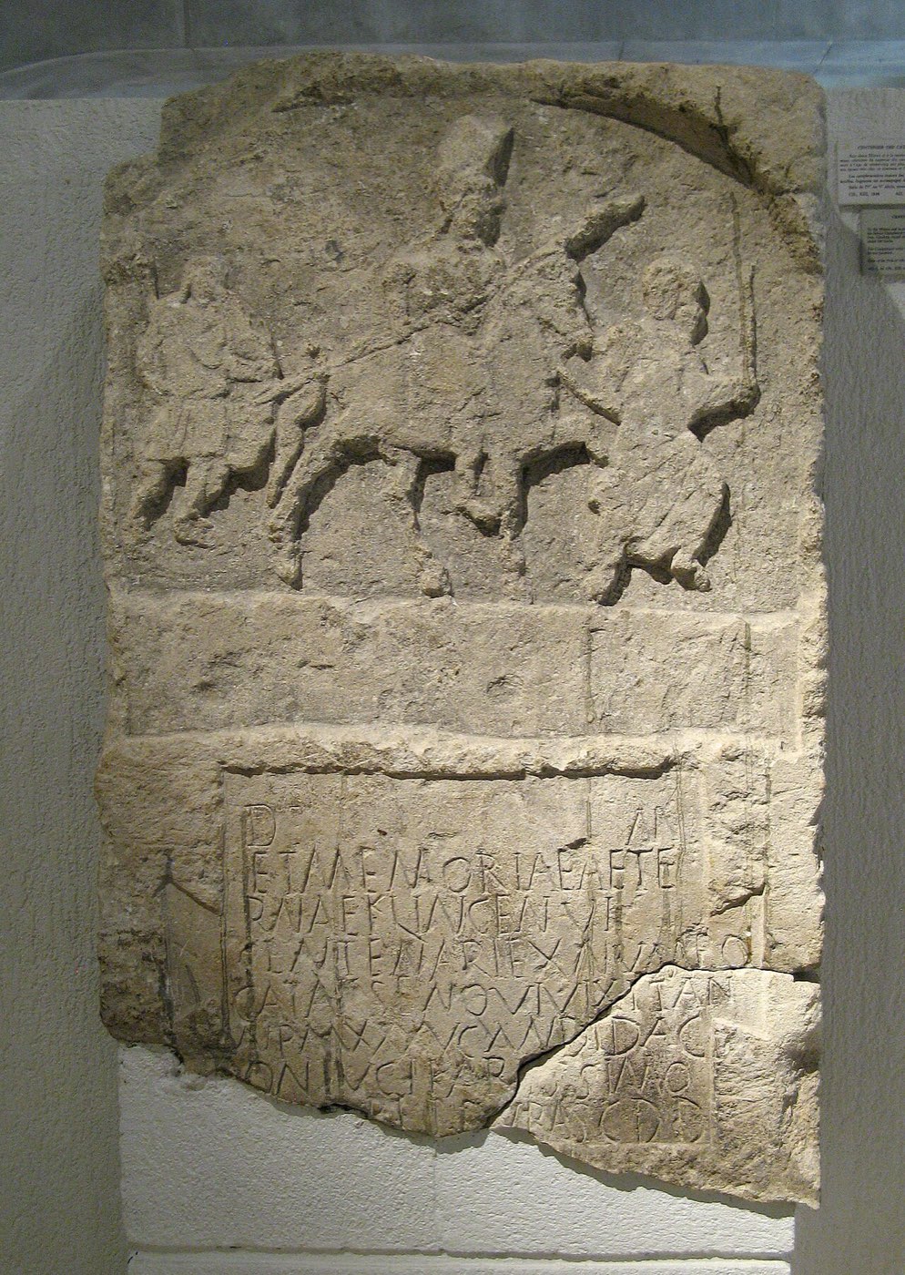 A Roman funerary stele carved with a soldier on horseback and an inscription panel below.