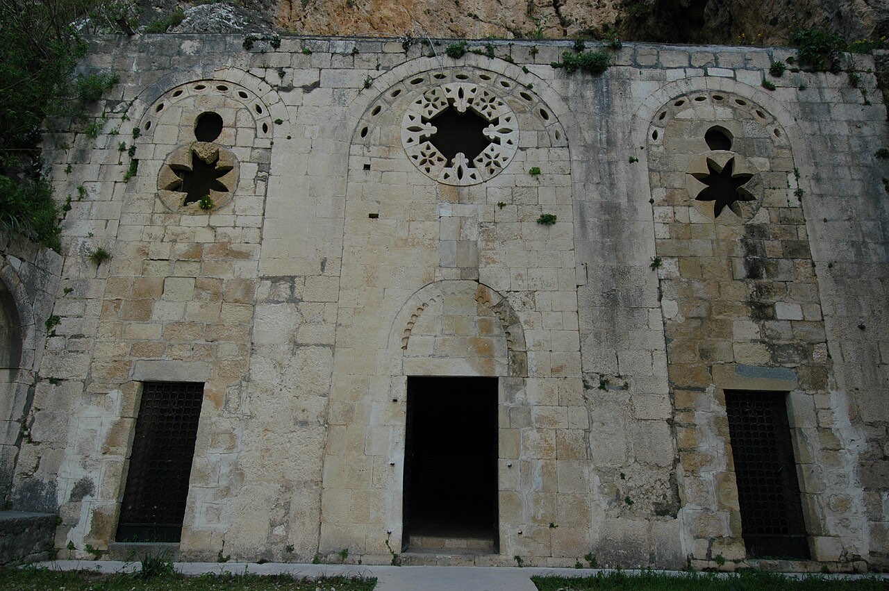The carved stone facade of the cave Church of St. Peter at Antakya, built into the rocky hillside.