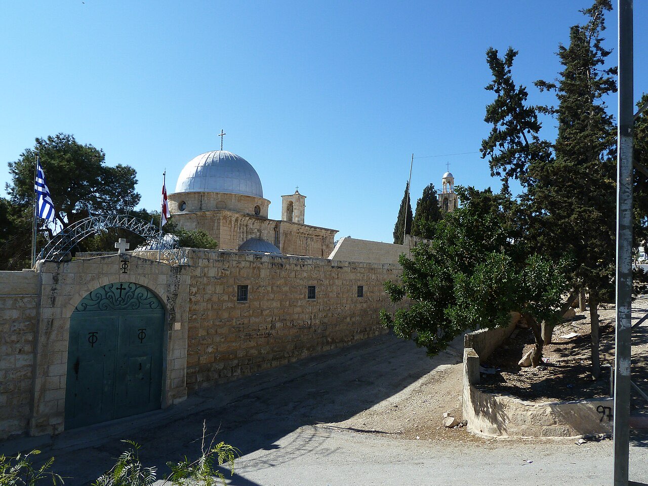 The stone Church of Saint Lazarus at Bethany with its silver dome, seen across a courtyard.