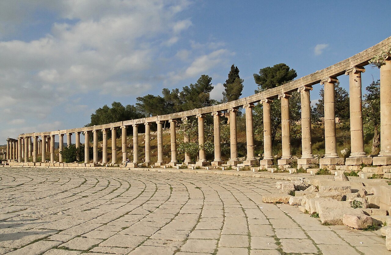 The oval forum of ancient Jerash: a sweeping ellipse of paving stones ringed by dozens of standing Ionic columns.