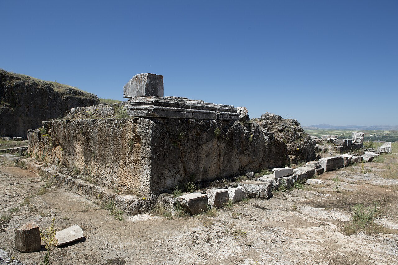 Ruins of the Temple of Augustus at Pisidian Antioch: cut stone foundations and a curved rock-hewn platform under an open sky.